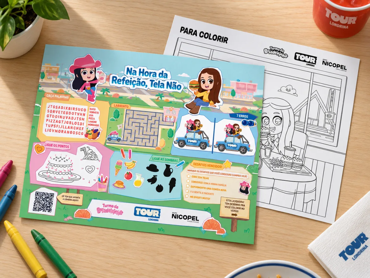 O papel-bandeja sobre a mesa, com caça-palavras, labirinto e jogo dos sete erros, ao lado da folha para colorir e de giz de cera